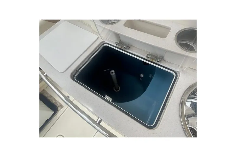 Slide: The Image of 2017 Scout 320 LXF boat interior with open storage compartment and cup holders. - 58