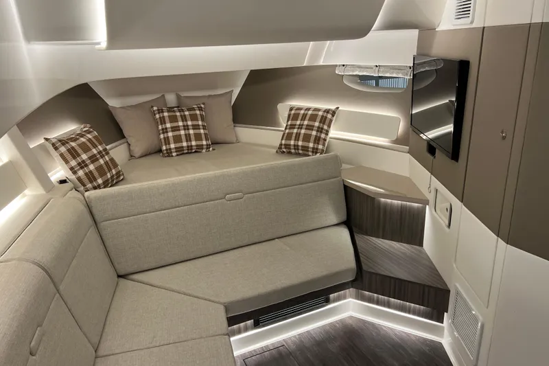 Slide: The Image of Luxurious interior of 2025 Sea Ray Sundancer 370 Outboard with modern seating and plaid pillows. - 19
