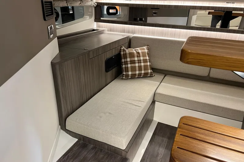 Slide: The Image of Interior of 2025 Sea Ray Sundancer 370 Outboard with cozy seating and plaid pillow. - 22