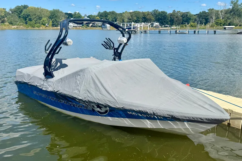 Slide: The Image of 2000 Correct Craft Super Air Nautique boat covered, docked on a sunny lake. - 15
