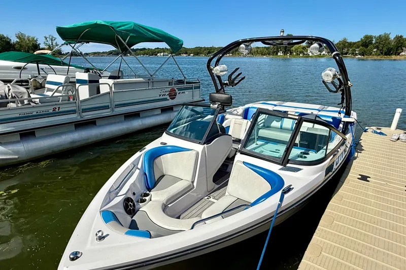 Slide: The Image of 2000 Correct Craft Super Air Nautique boat docked on a sunny lake. - 2