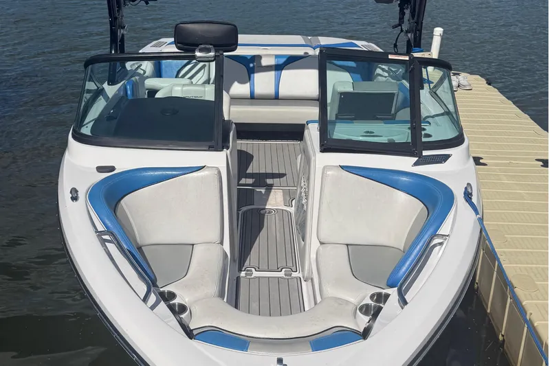Slide: The Image of 2000 Correct Craft Super Air Nautique boat with blue and white interior, docked on water. - 4