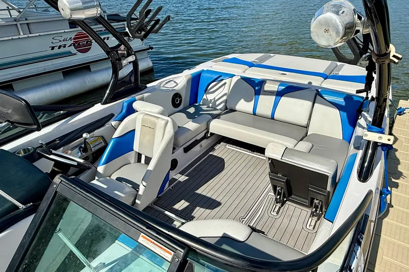 Slide: The Image of 2000 Correct Craft Super Air Nautique boat interior with blue and gray seating, docked by water. - 5