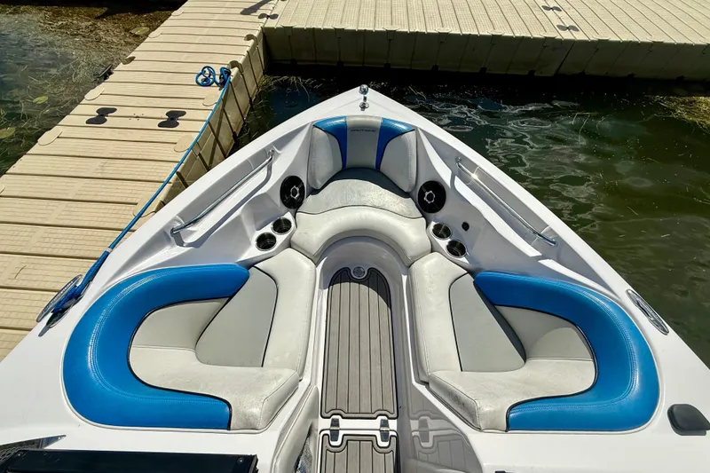Slide: The Image of 2000 Correct Craft Super Air Nautique boat interior with blue and gray seating at dock. - 9
