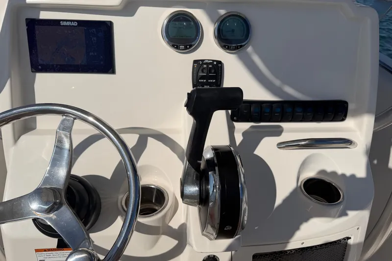 Slide: The Image of Control panel of 2023 Sailfish 220 CC boat with steering wheel and navigation instruments. - 16