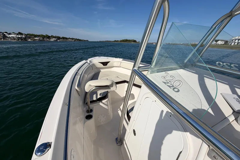 Slide: The Image of 2023 Sailfish 220 CC boat on calm water, showcasing sleek design and spacious deck. - 17