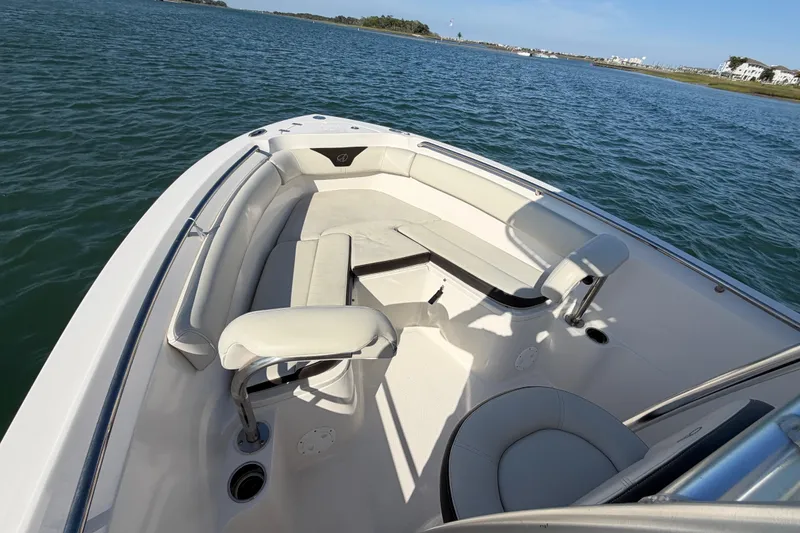 Slide: The Image of 2023 Sailfish 220 CC boat interior with seating, on calm water. - 18