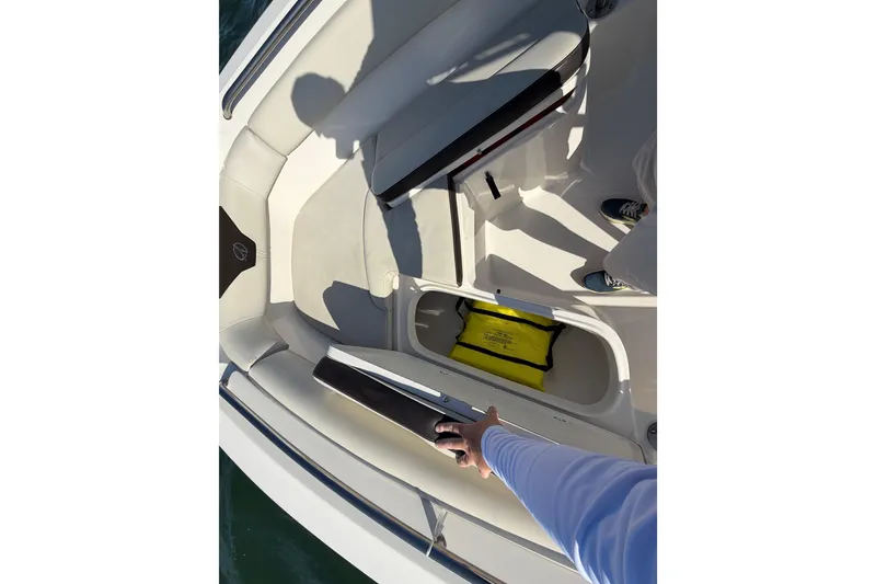 Slide: The Image of 2023 Sailfish 220 CC boat interior with open storage compartment and safety equipment. - 21