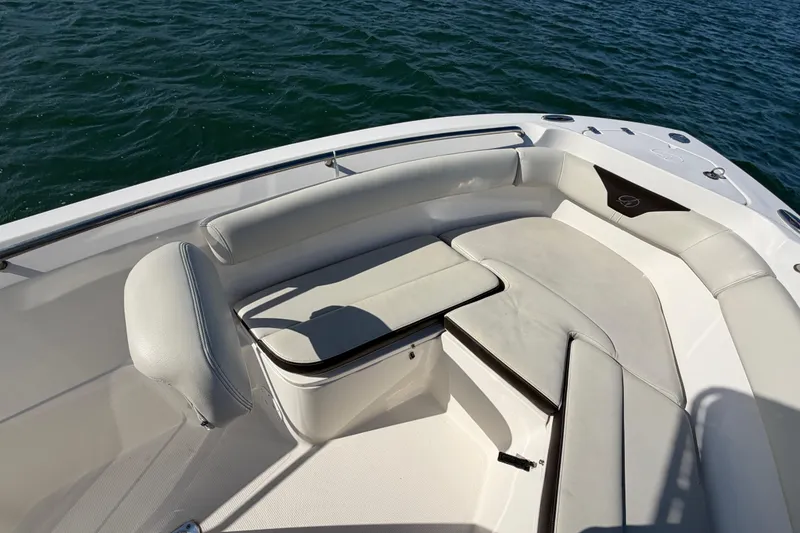 Slide: The Image of 2023 Sailfish 220 CC boat interior with cushioned seating, on calm water. - 22