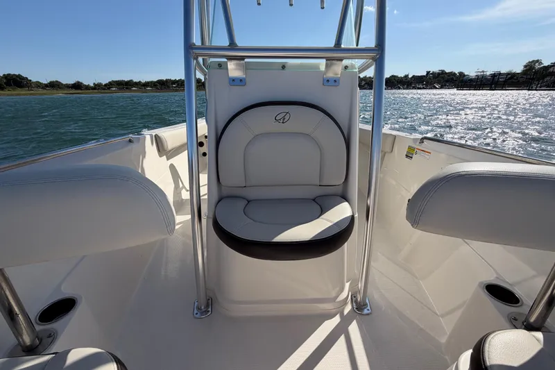 Slide: The Image of 2023 Sailfish 220 CC boat interior with cushioned seating, ocean view, and sunny weather. - 24