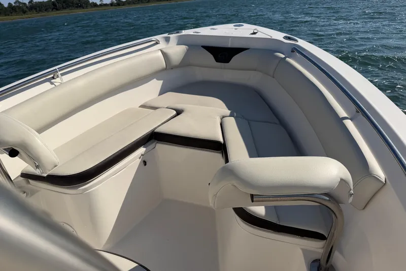 Slide: The Image of 2023 Sailfish 220 CC boat interior with cushioned seating, on calm water. - 34