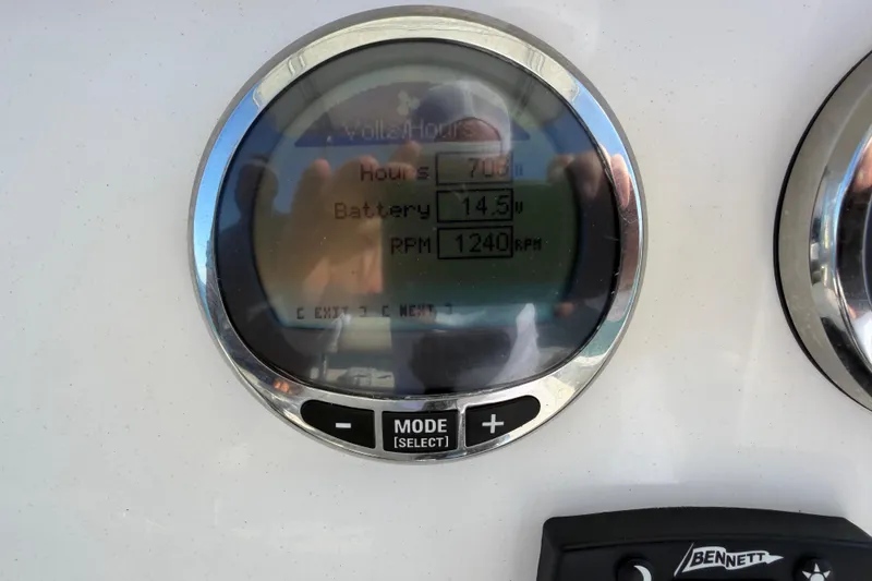 Slide: The Image of Close-up of a 2023 Sailfish 220 CC boat gauge displaying hours, battery voltage, and RPM. - 38