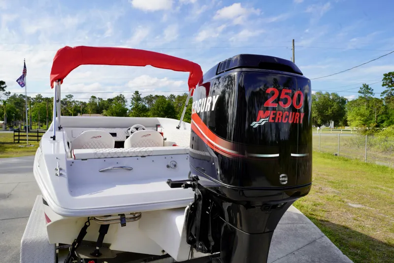 The Image of 1996 Baja 20 Outlaw boat with Mercury 250 engine and red canopy, parked outdoors. - 0