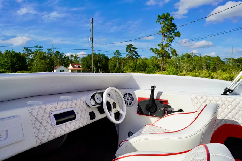 Slide: The Image of Interior of a 1996 Baja 20 Outlaw boat with white and red seating. - 10
