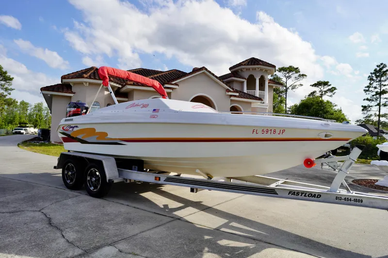 Slide: The Image of 1996 Baja 20 Outlaw boat on trailer, parked in front of a luxurious house. - 2