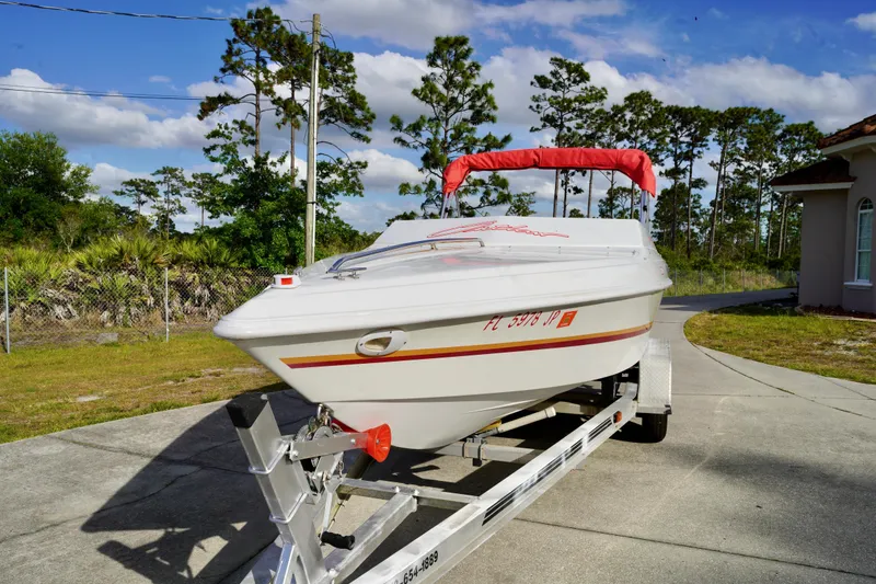 Slide: The Image of 1996 Baja 20 Outlaw speedboat on trailer, parked outdoors under a clear sky. - 3