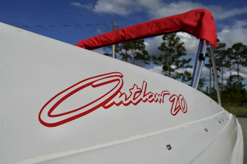 Slide: The Image of 1996 Baja 20 Outlaw boat with red lettering and canopy against a blue sky. - 6