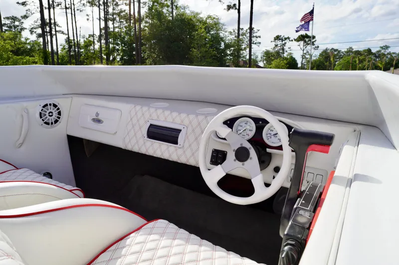 Slide: The Image of 1996 Baja 20 Outlaw boat interior with white and red upholstery, steering wheel, and gauges. - 9