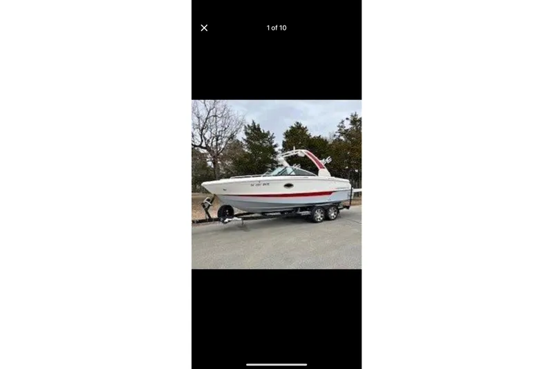 The Image of 2020 Chaparral 25 Surf boat on trailer, parked outdoors. - 1