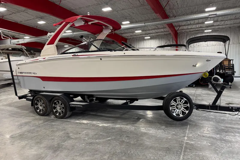 The Image of 2020 Chaparral 25 Surf boat on trailer in indoor showroom. - 6