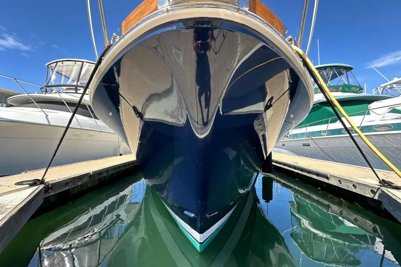 Slide: The Image of 2003 Grand Banks 43 Eastbay HX yacht docked, reflecting in calm marina waters. - 12