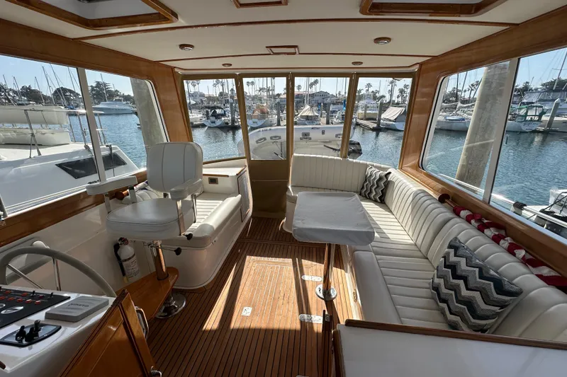 Slide: The Image of Luxurious 2003 Grand Banks 43 Eastbay HX yacht interior with plush seating and scenic marina view. - 13
