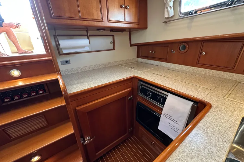 Slide: The Image of 2003 Grand Banks 43 Eastbay HX yacht kitchen with wood cabinetry and modern appliances. - 23