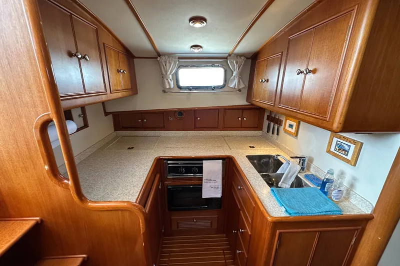 Slide: The Image of Luxurious 2003 Grand Banks 43 Eastbay HX yacht kitchen with wooden cabinetry and modern amenities. - 24