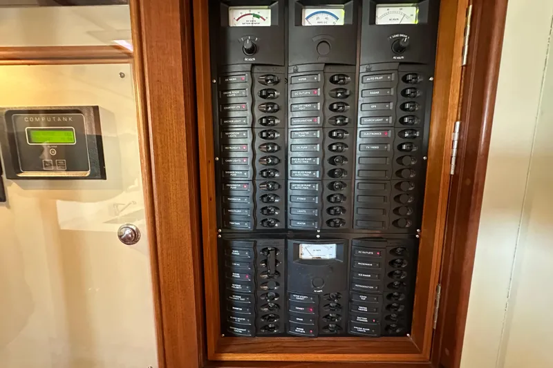 Slide: The Image of Electrical panel of a 2003 Grand Banks 43 Eastbay HX yacht, featuring various switches and gauges. - 29