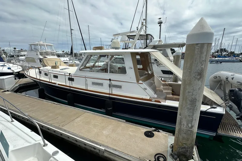Slide: The Image of 2003 Grand Banks 43 Eastbay HX yacht docked at marina under cloudy sky. - 4