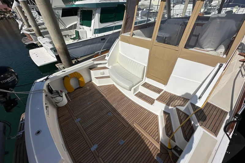 Slide: The Image of 2003 Grand Banks 43 Eastbay HX yacht deck with seating and wooden flooring. - 9