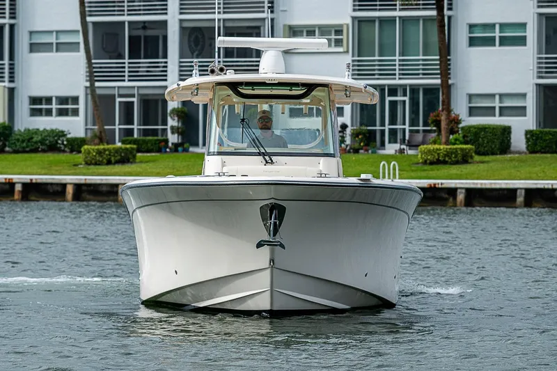 Slide: The Image of 2020 Grady-White Canyon 336 boat cruising near waterfront homes. - 10