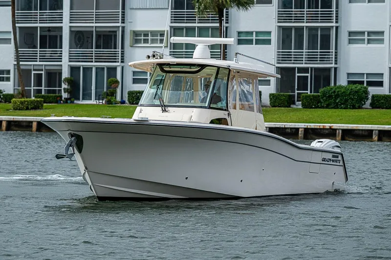Slide: The Image of 2020 Grady-White Canyon 336 boat cruising near waterfront buildings. - 11