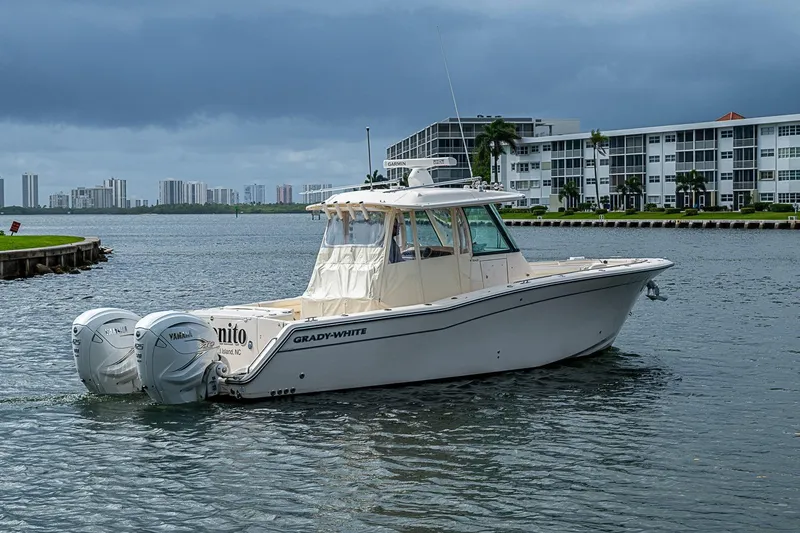 Slide: The Image of 2020 Grady-White Canyon 336 boat on water near modern buildings. - 12