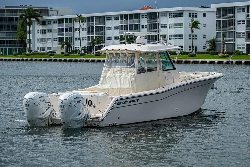 Slide: The Image of 2020 Grady-White Canyon 336 boat with twin Yamaha engines on a calm waterway. - 13