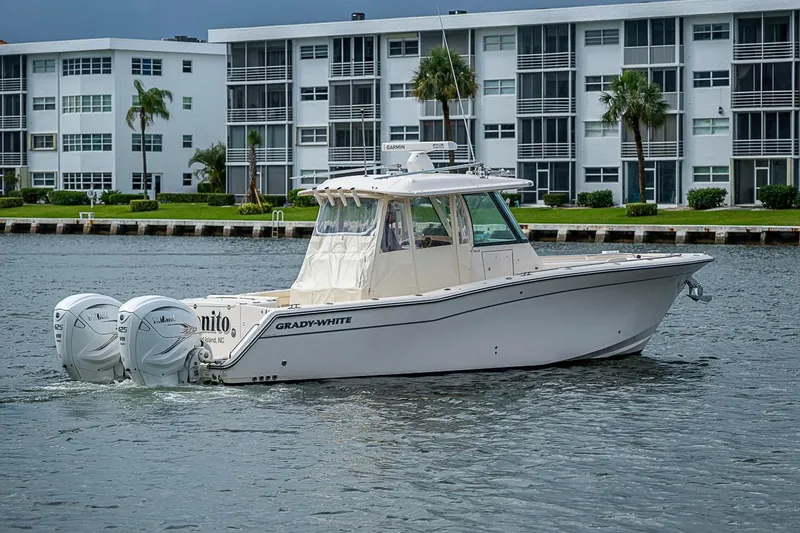 Slide: The Image of 2020 Grady-White Canyon 336 boat cruising near waterfront buildings. - 14