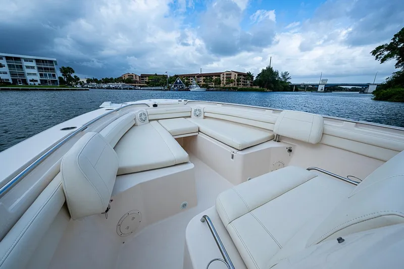 Slide: The Image of 2020 Grady-White Canyon 336 boat interior with luxurious seating on a scenic waterway. - 19