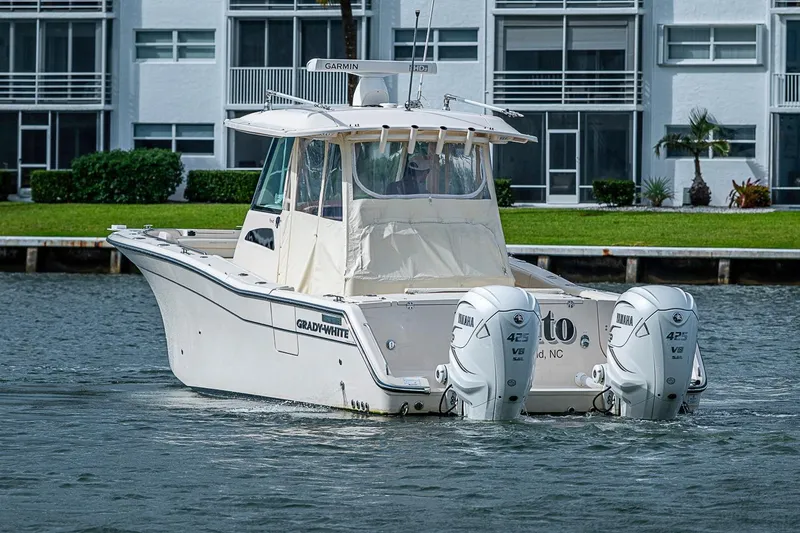 Slide: The Image of 2020 Grady-White Canyon 336 boat with twin Yamaha engines on a calm waterway. - 2