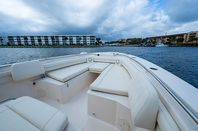 Slide: The Image of 2020 Grady-White Canyon 336 boat with spacious seating, docked near waterfront buildings. - 20