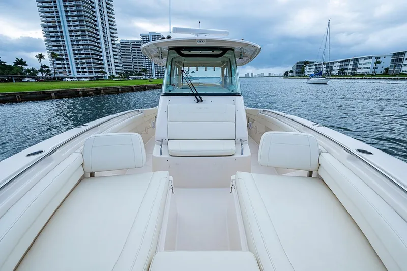 Slide: The Image of 2020 Grady-White Canyon 336 boat on water, with luxury seating and cityscape backdrop. - 22