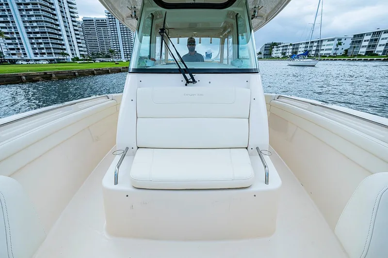 Slide: The Image of 2020 Grady-White Canyon 336 boat interior with seating, docked near waterfront buildings. - 23