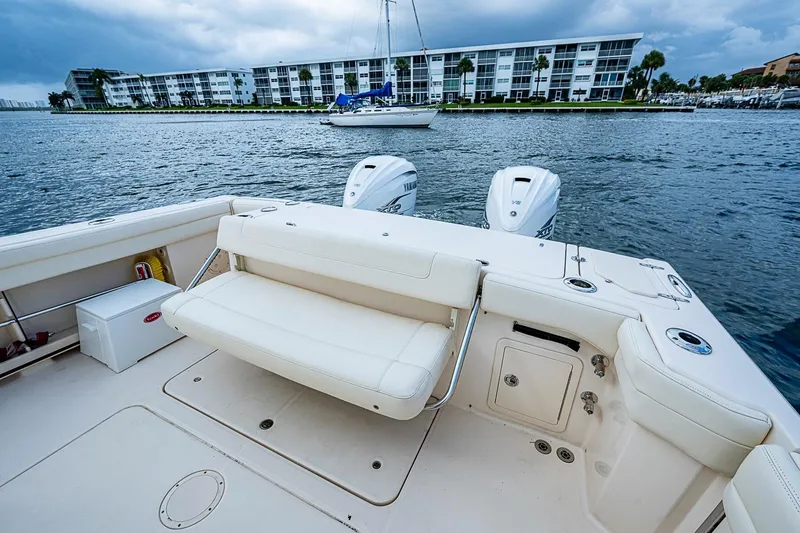 Slide: The Image of 2020 Grady-White Canyon 336 boat with dual engines, docked near waterfront buildings. - 24