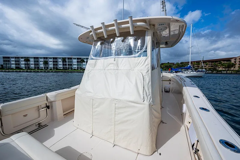 Slide: The Image of 2020 Grady-White Canyon 336 boat with covered helm, docked near waterfront buildings. - 28