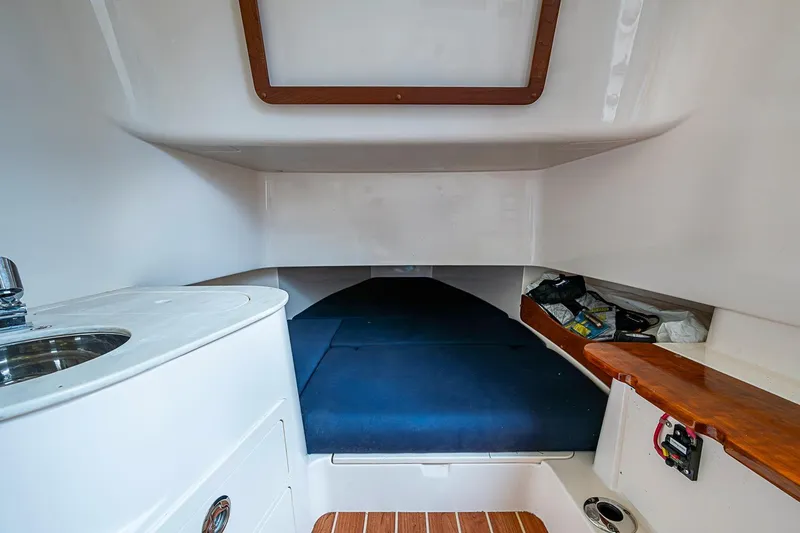 Slide: The Image of 2020 Grady-White Canyon 336 cabin interior with sink and blue cushioned seating. - 30