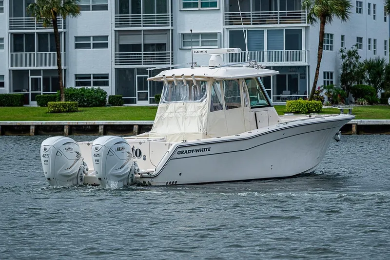 Slide: The Image of 2020 Grady-White Canyon 336 boat with twin Yamaha engines on a calm waterway. - 4