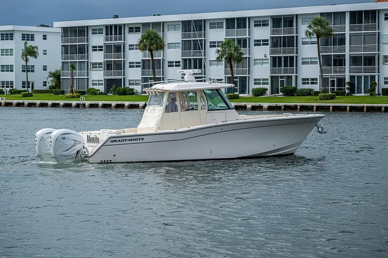 Slide: The Image of 2020 Grady-White Canyon 336 boat cruising near waterfront apartments. - 5