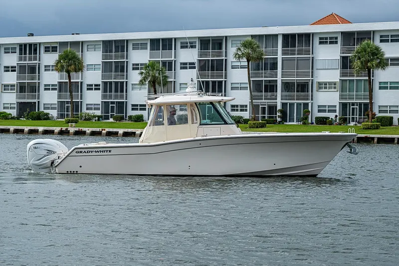 Slide: The Image of 2020 Grady-White Canyon 336 boat on water near modern waterfront apartments. - 6