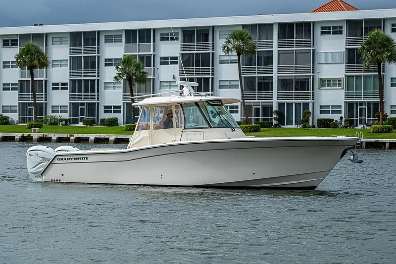 Slide: The Image of 2020 Grady-White Canyon 336 boat cruising near waterfront apartments. - 7