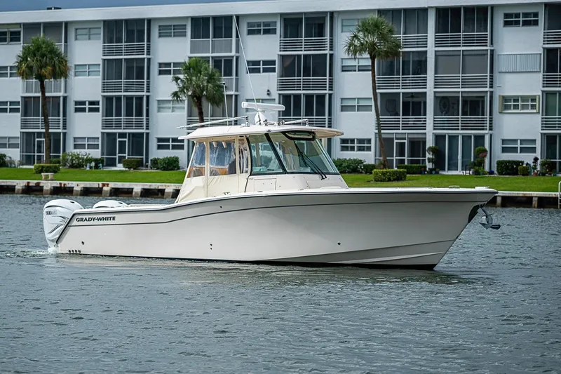 Slide: The Image of 2020 Grady-White Canyon 336 boat cruising near waterfront buildings. - 8