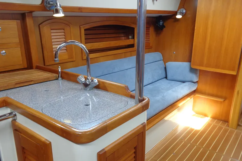 Slide: The Image of Interior of 2009 Pacific Seacraft 34 yacht with wooden cabinetry and blue sofa. - 3